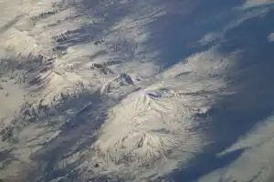 An oblique view of Mount Ararat in eastern Turkey, its twin snowy peaks rising above the surrounding terrain, photographed from the International Space Station